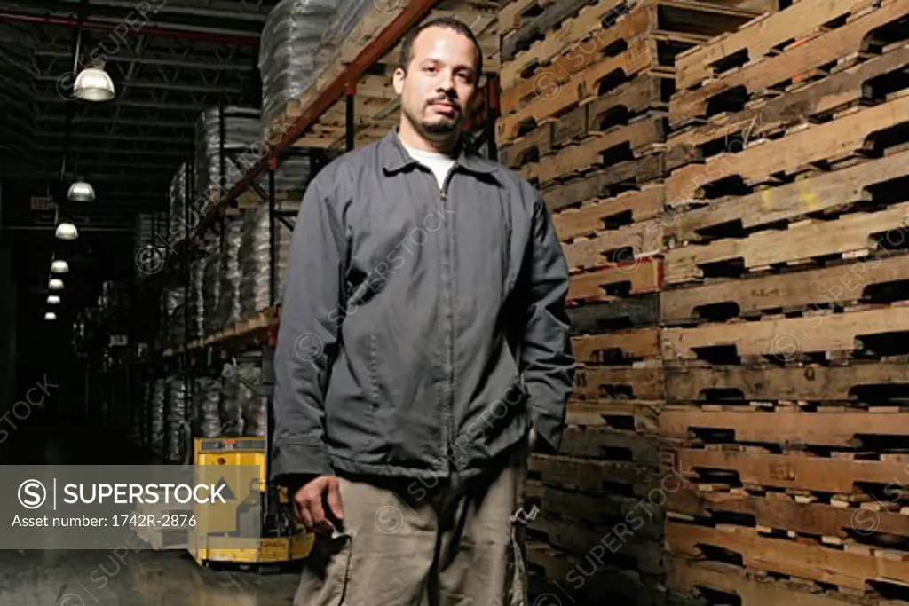 View of a man standing inside a warehouse.
