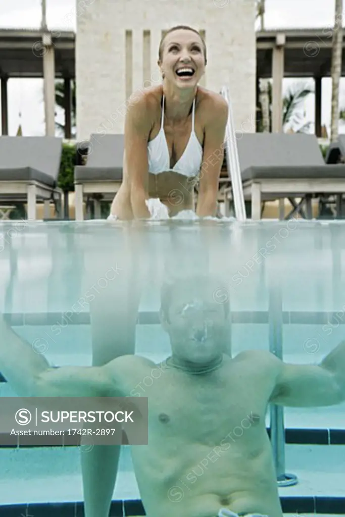 View of a couple underwater in a swimming pool.