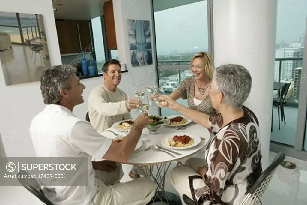 Group of 4 people toasting over a meal