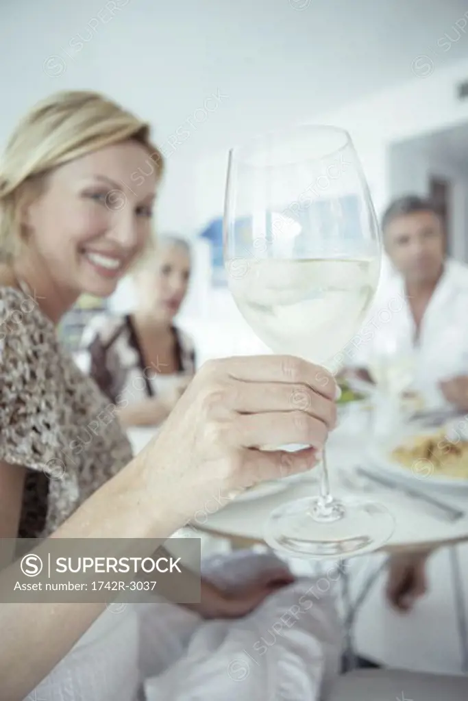 Women holding up a wine glass among a group