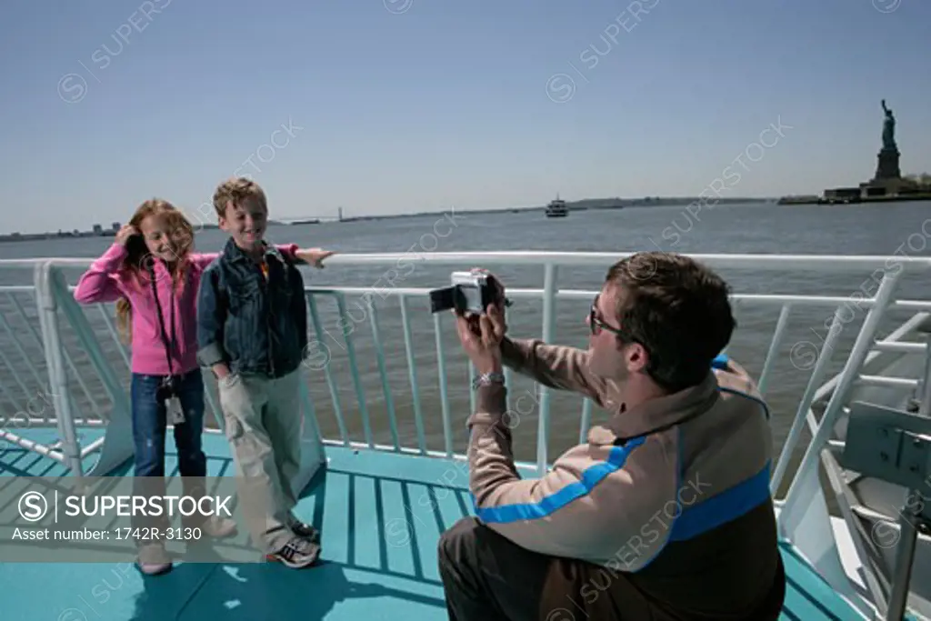 Man recording children on a boat
