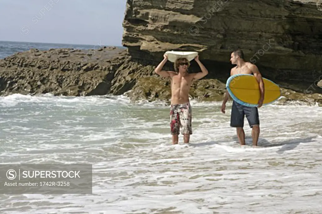 View of two men ready for surfboarding.