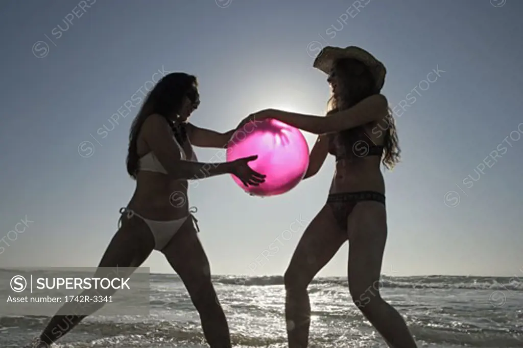 View of two women playing on a beach.
