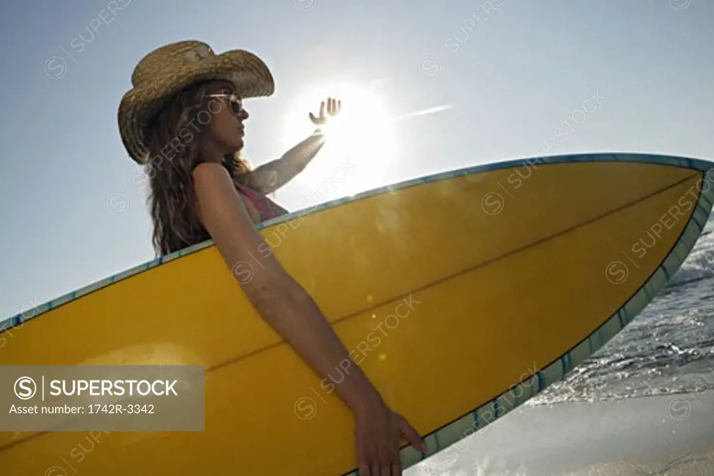 View of a woman with a surfboard.