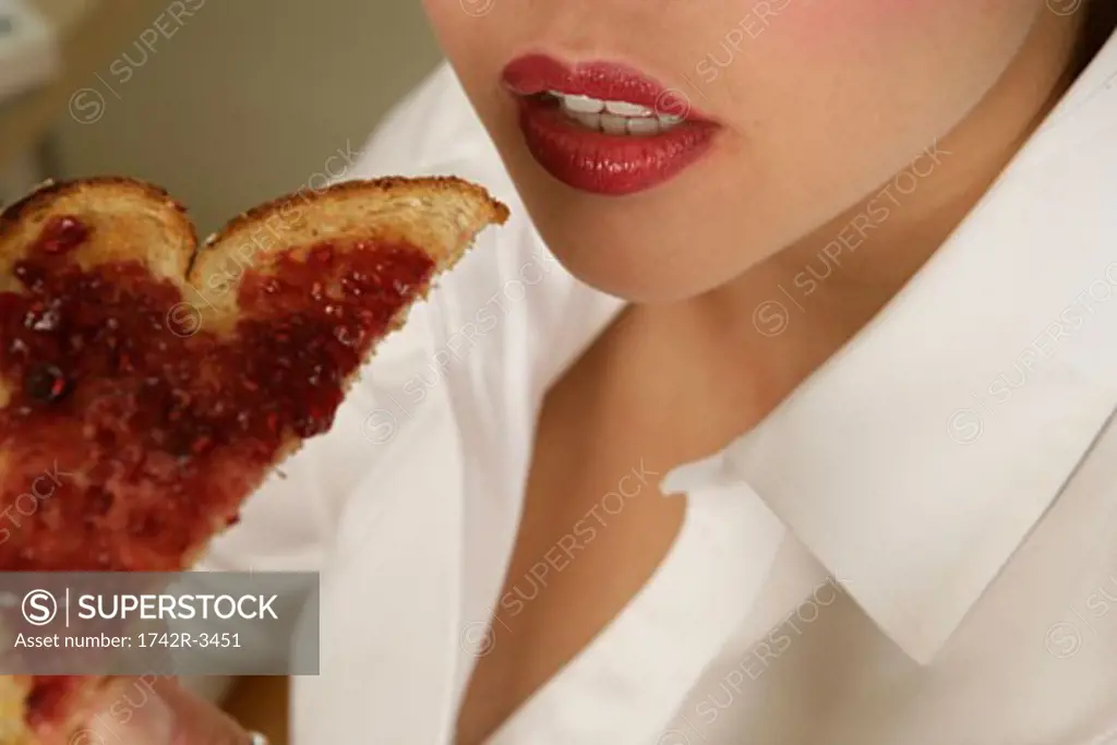 Young woman eating slice of bread, close-up
