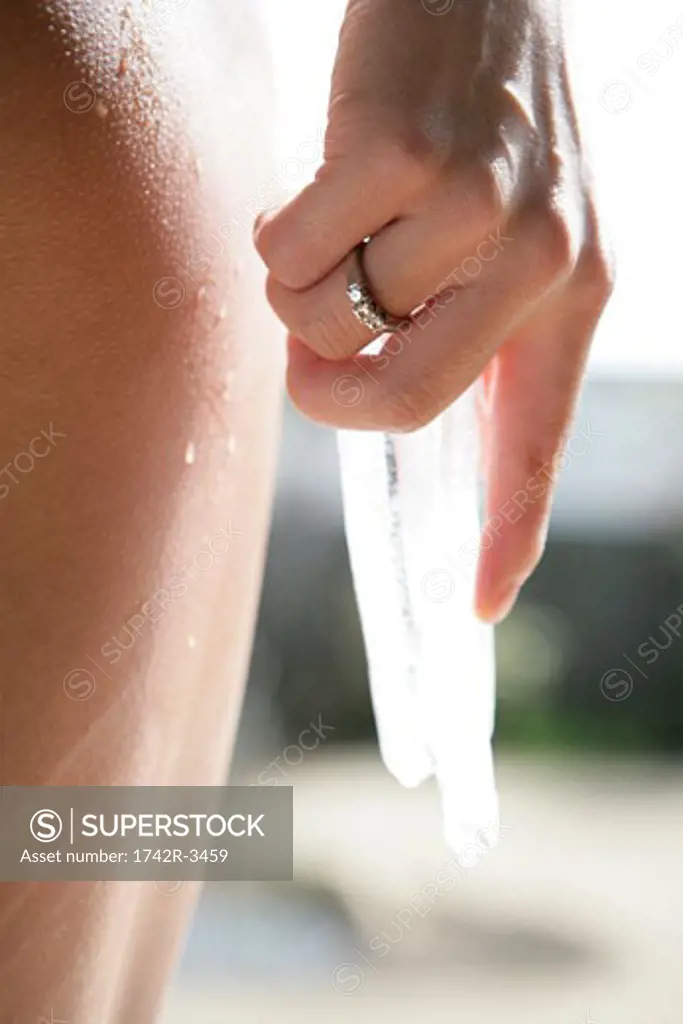 Young woman holding ice, close-up