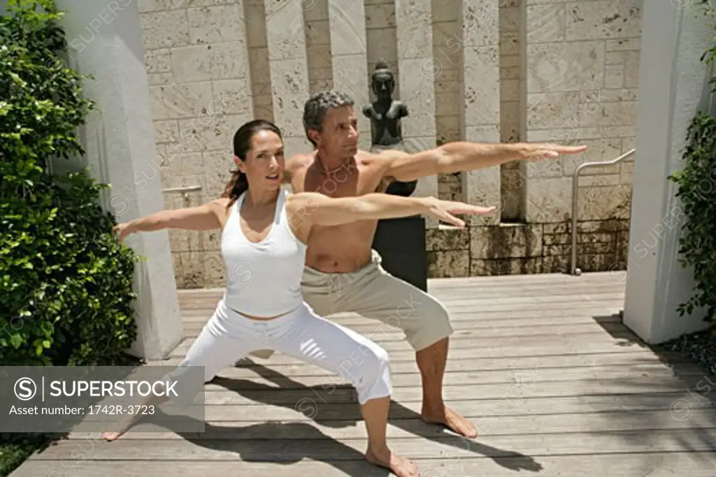 View of a couple practicing yoga.