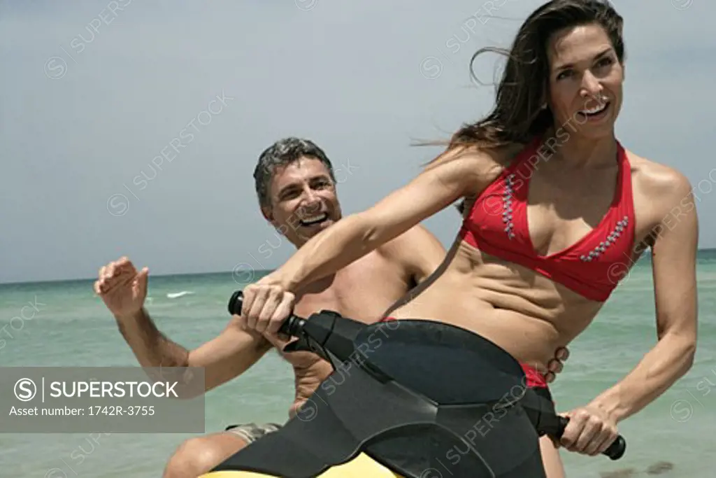 View of a couple riding a water scooter.