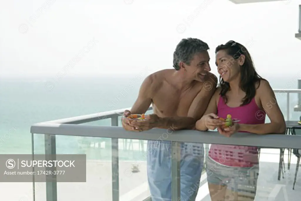 Couple looking into each other's eyes on balcony