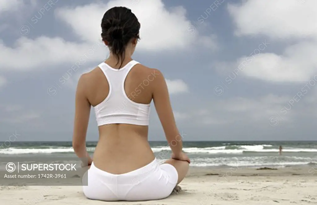 A woman is sitting on a beach.