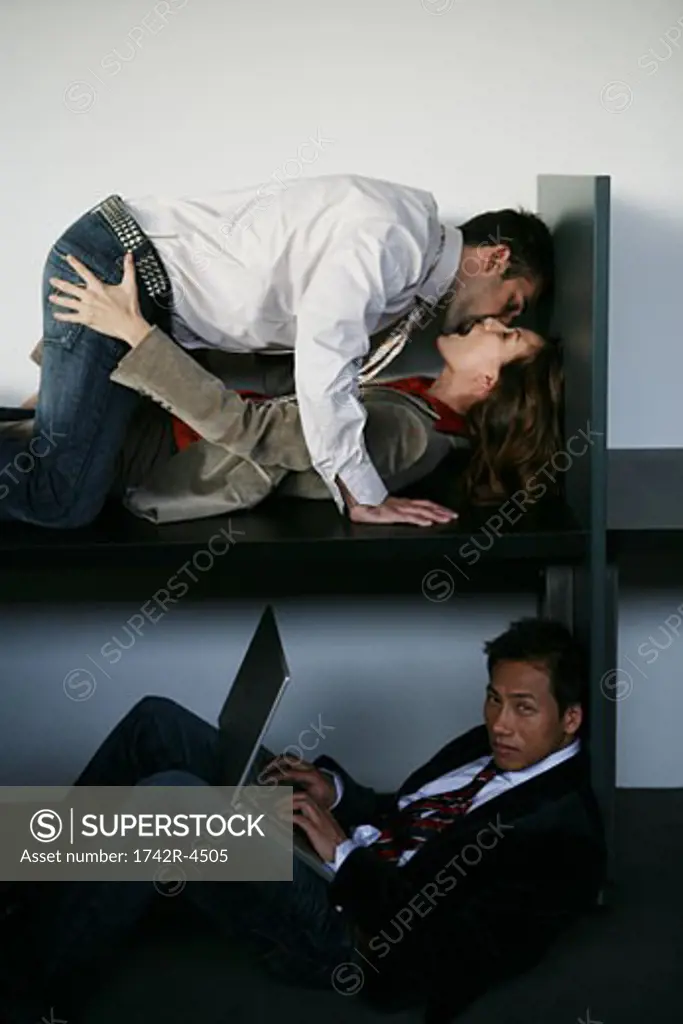 Three people in an office, two people having an affair