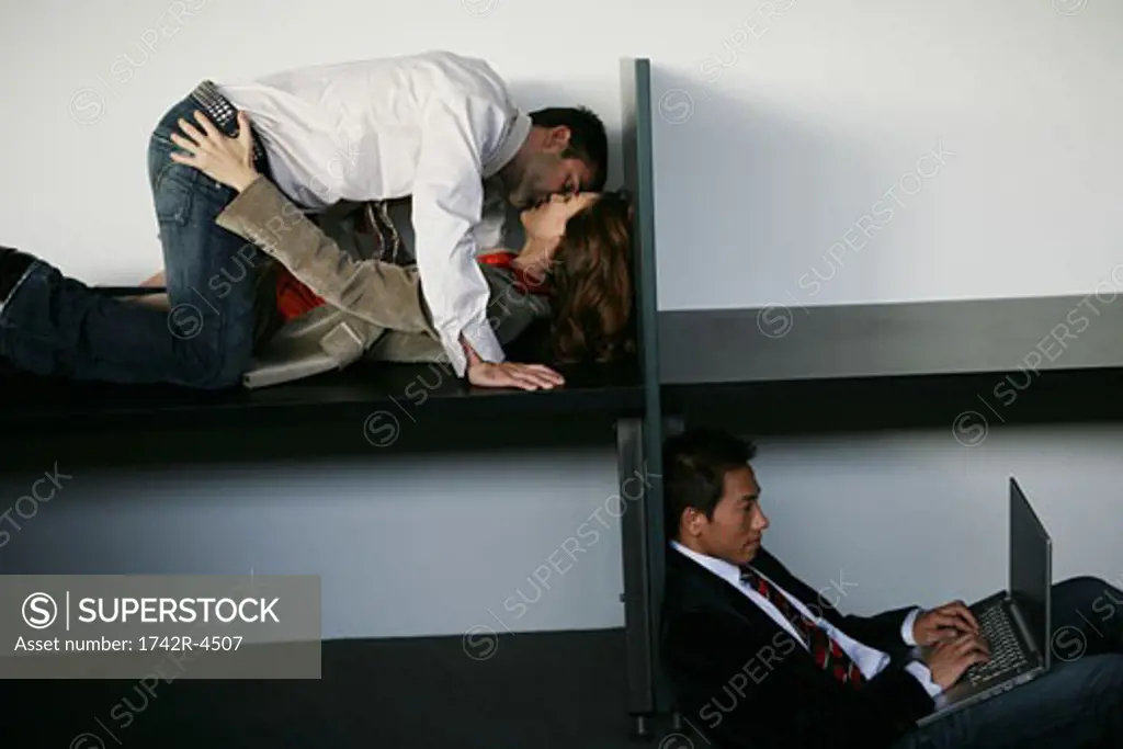 Three people in an office, two people having an affair