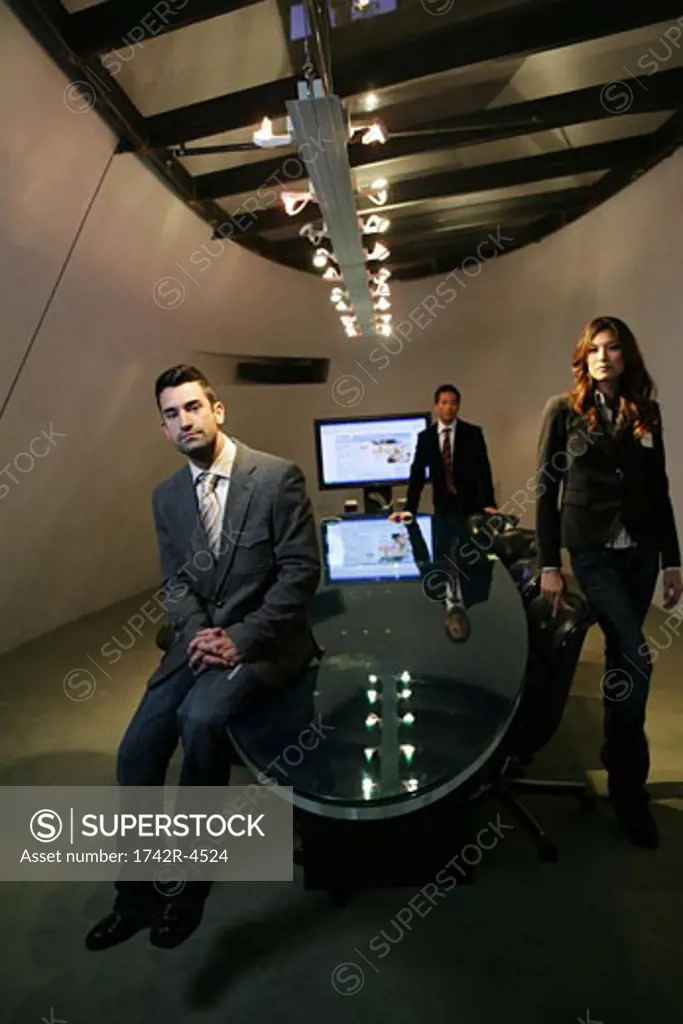 Three people inside a conference room