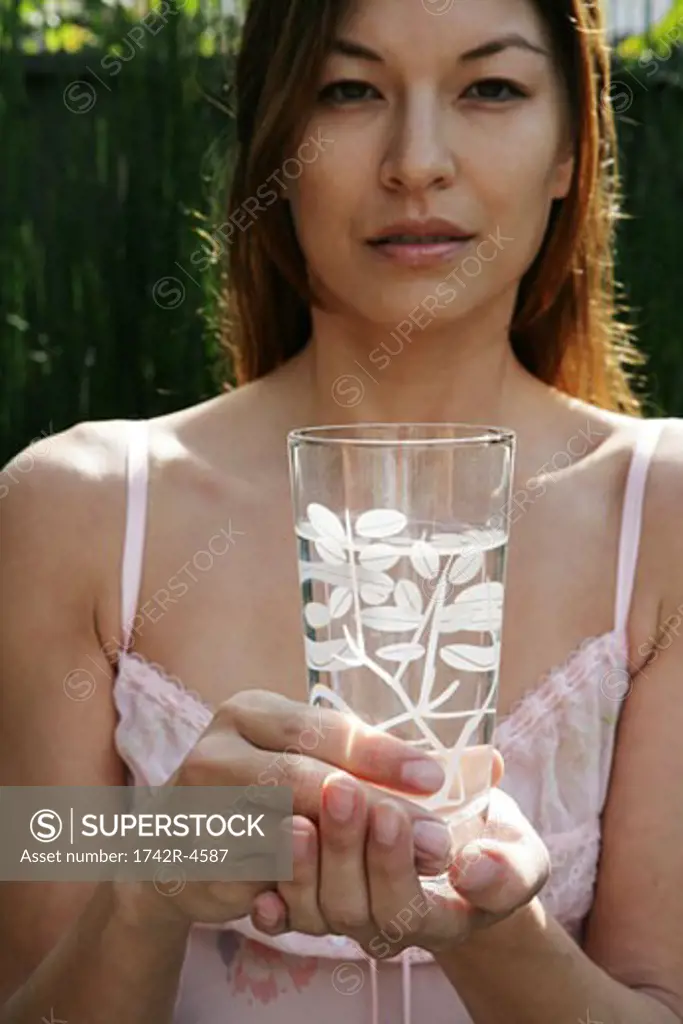 Asian woman holding a glass of water