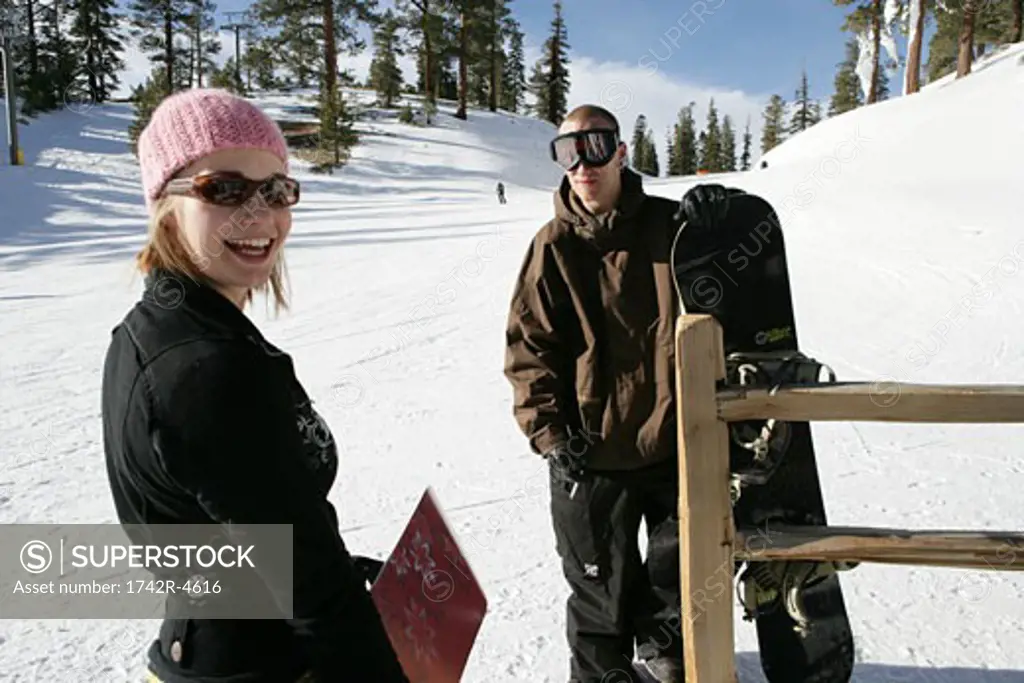 Woman and man standing on ski slope