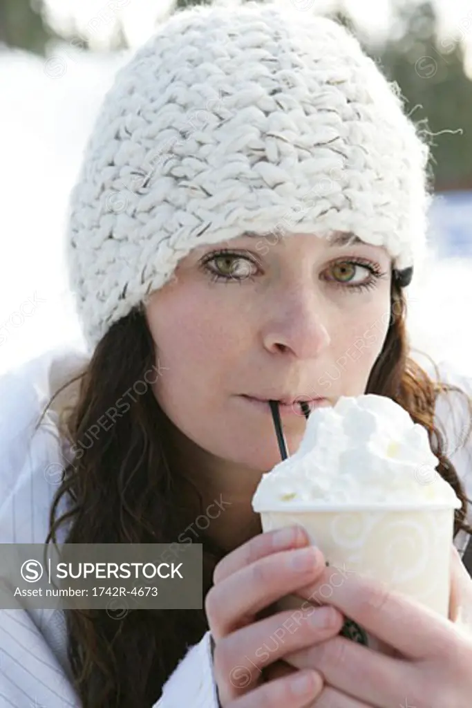 Woman drinking a hot drink with whip cream