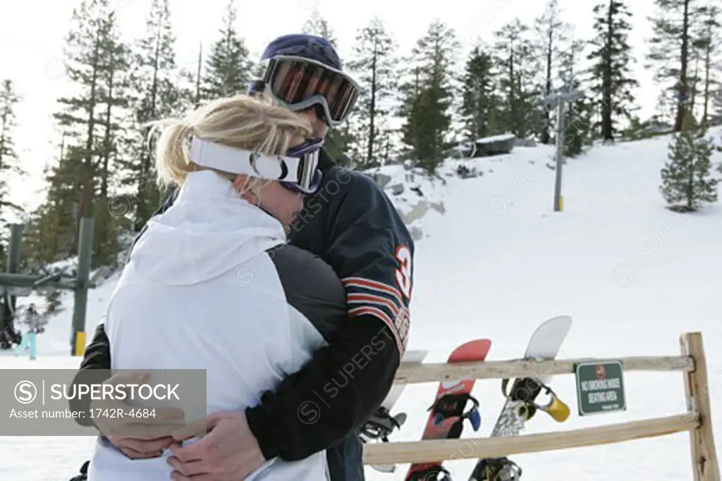 Couple hugging on a ski slope