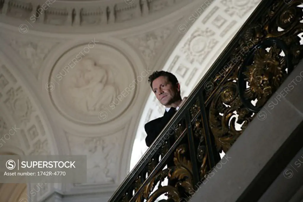 Mature man standing on a staircase