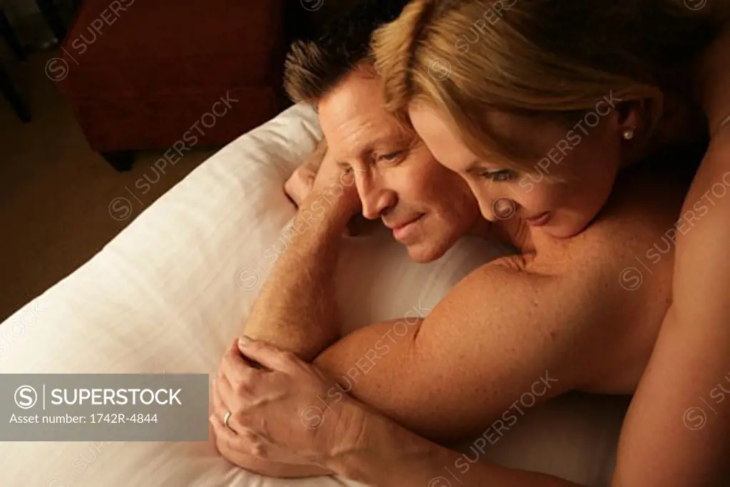 Mature couple in bed smiling