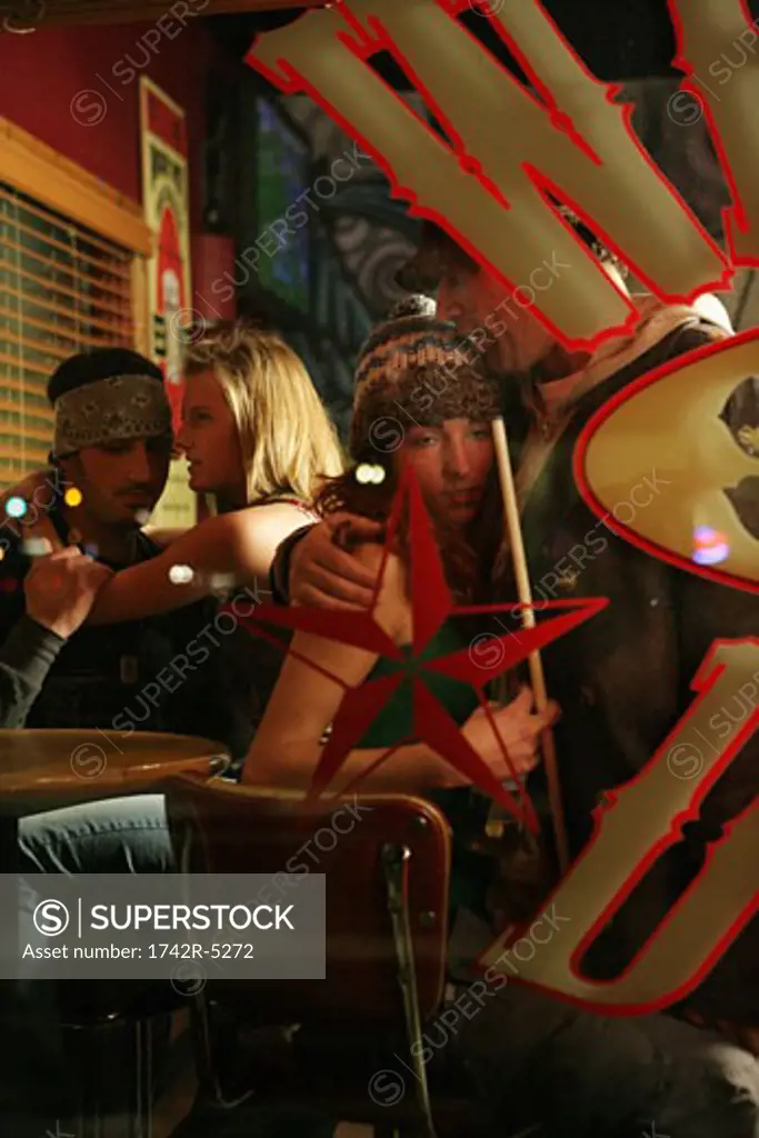 Two couples inside a pool hall