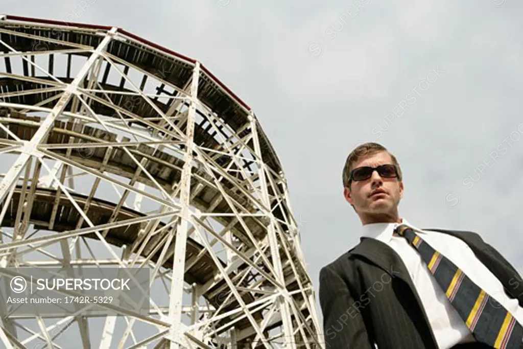 Business man standing beside a large metal structure