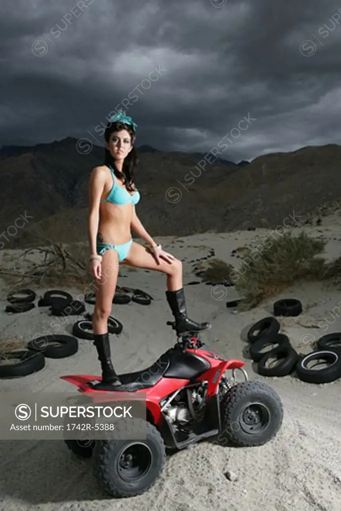 Young woman standing on an ATV