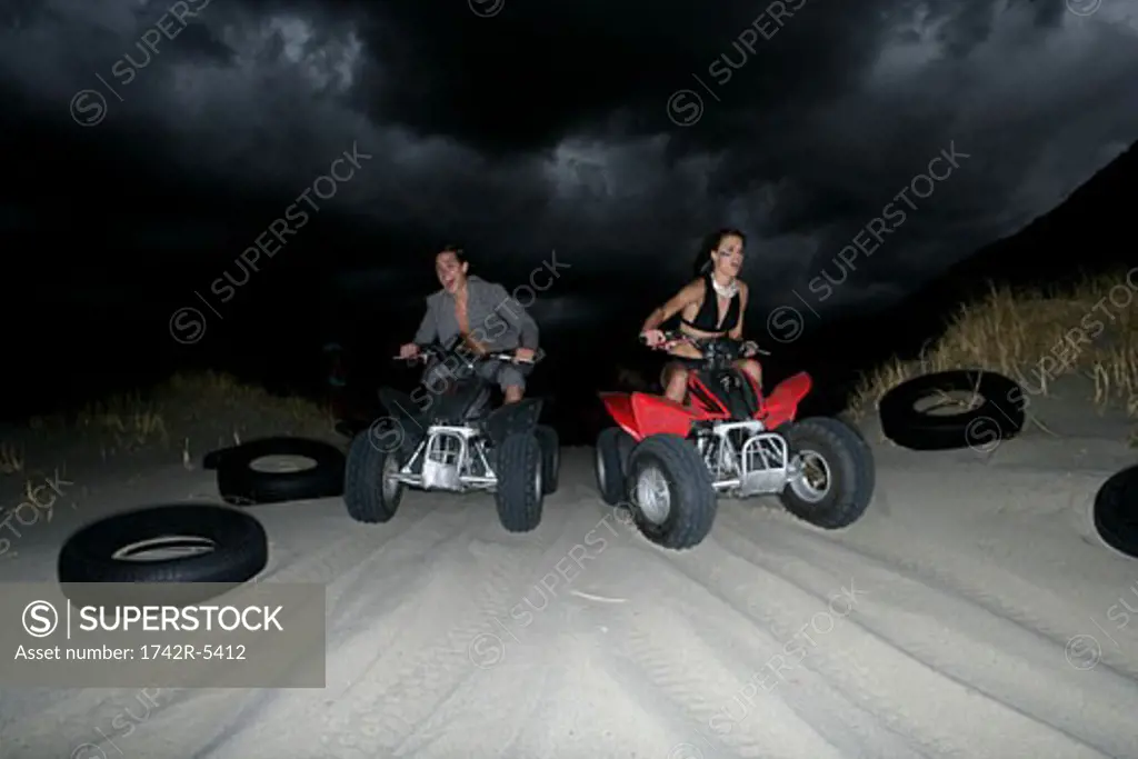 Young couple riding ATVs