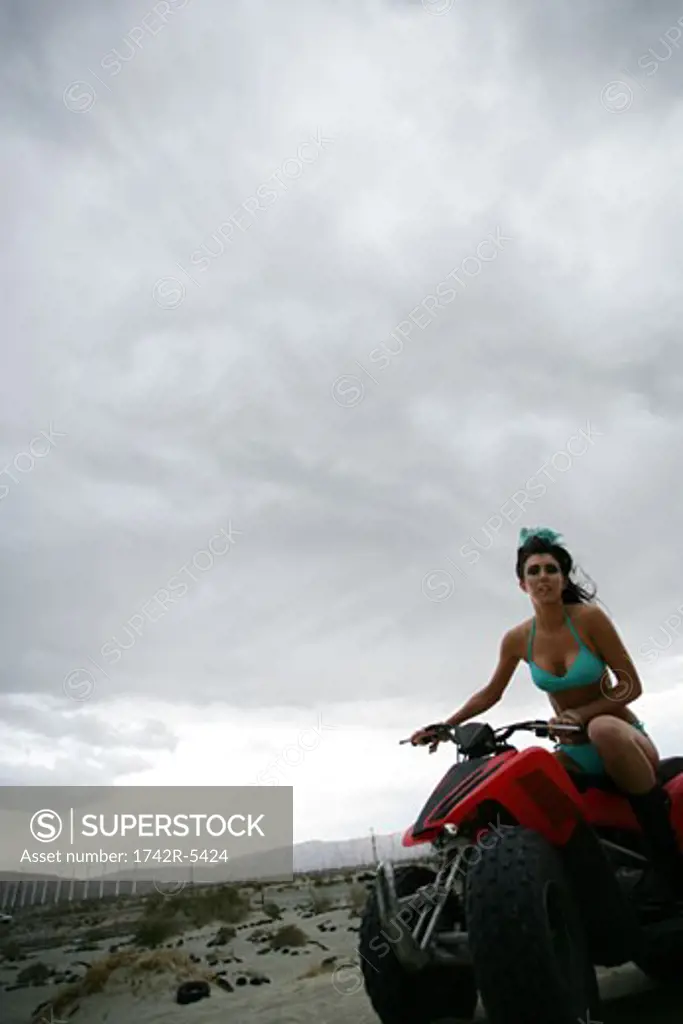 Young woman in bikini riding an ATV  