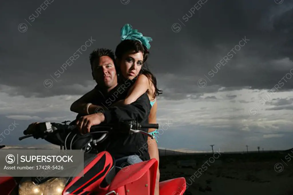 Young couple riding ATV 