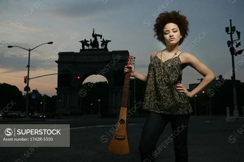 african american female posing in brooklyn with travel guitar