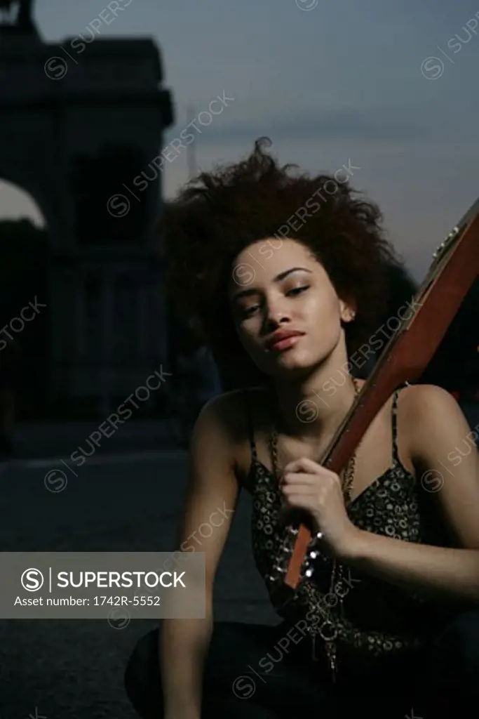 african american female posing with travel guitar outside