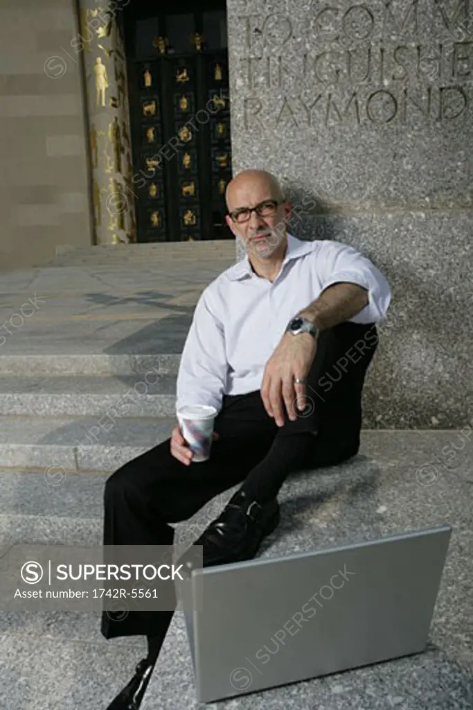 mature man resting outside with laptop