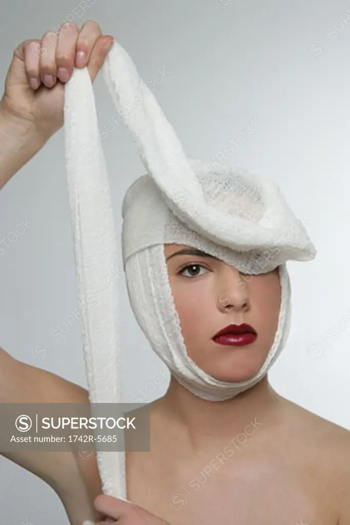 Woman unwrapping bandage around her head