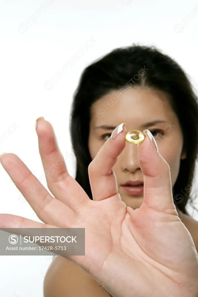 Woman holding up a capsule in front of camera