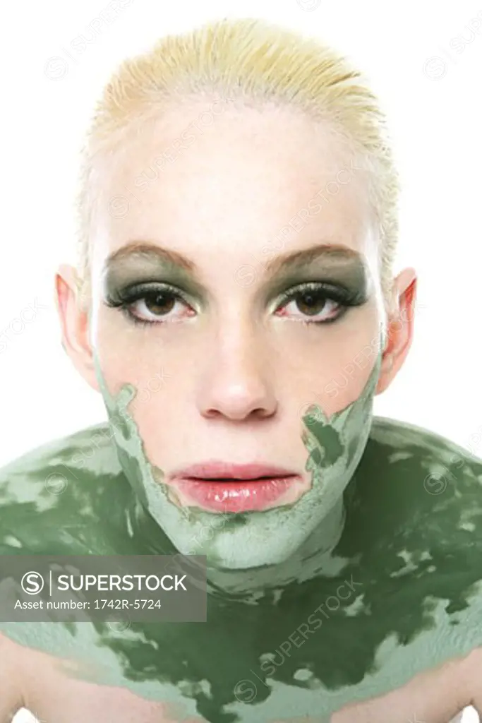Young woman wearing a green mask on her face, neck and shoulders