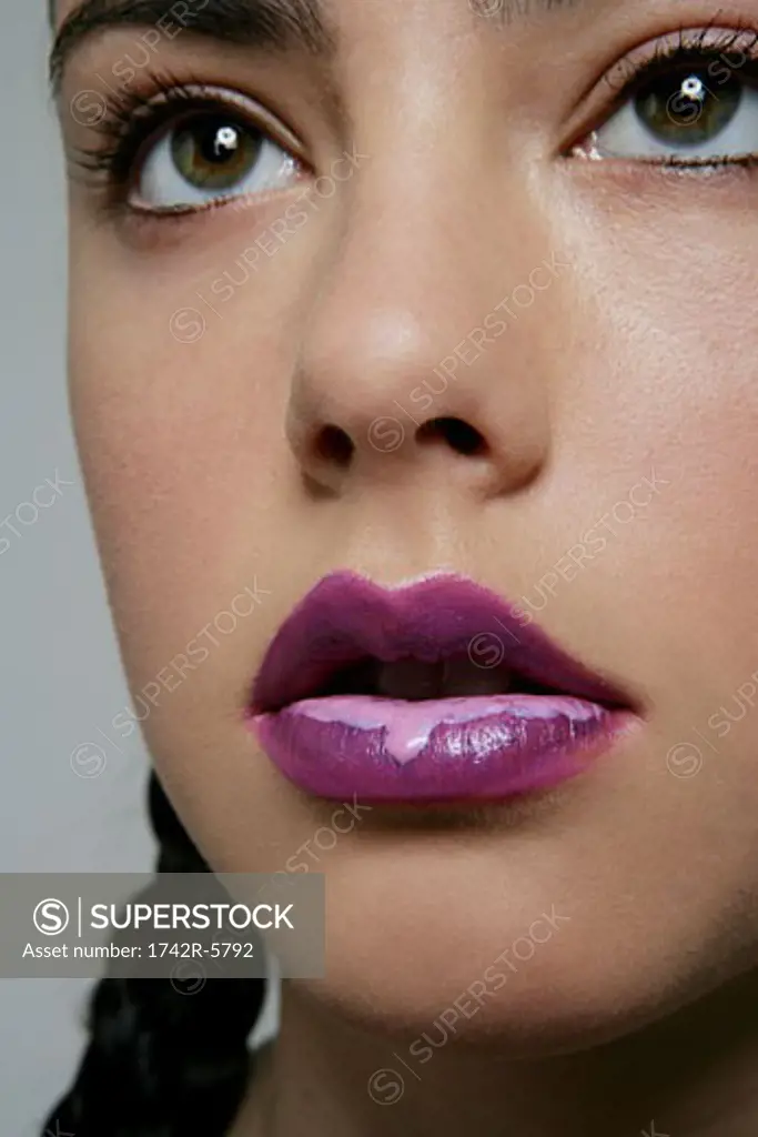 Portrait of Caucasian woman with dripping lip gloss