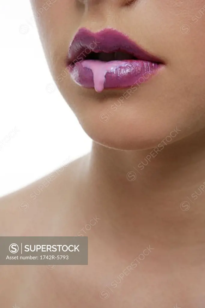 Portrait of Caucasian woman with dripping lip gloss