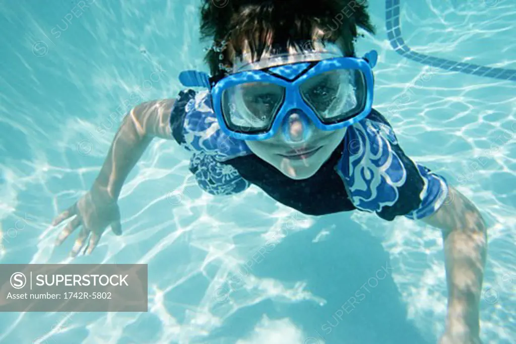 Little boy swimming, wearing goggles