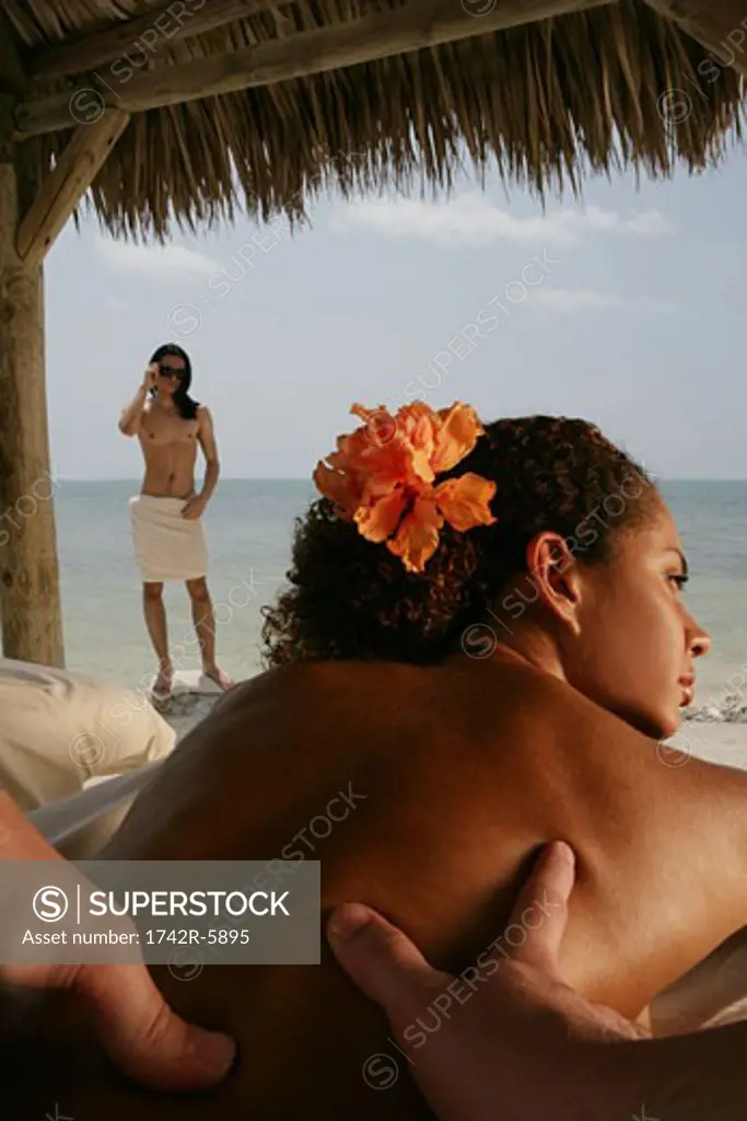 Young woman getting back massage at beach.