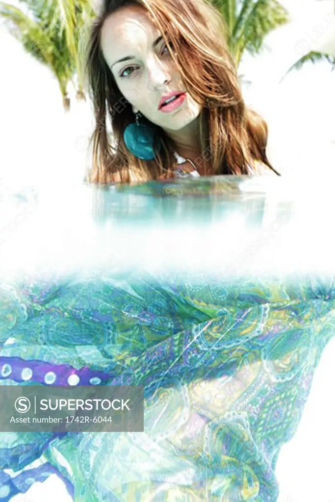Fully-dressed young woman underwater.