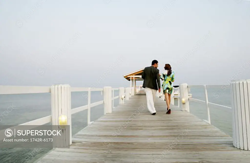 Young couple walking on pier.