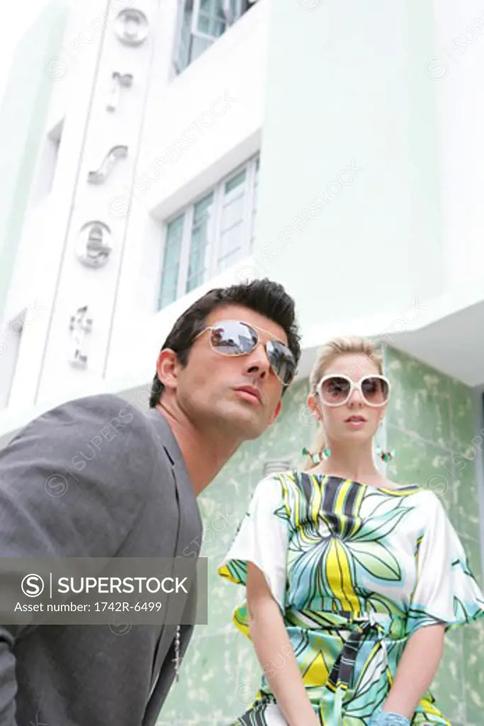 Fashionable couple waiting outside hotel.