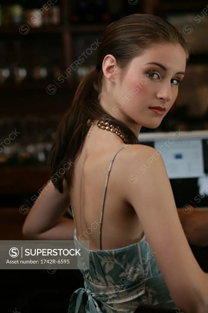Young woman sitting at bar in cafe.