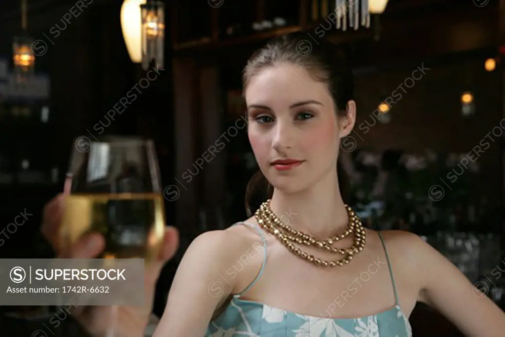 Young woman with wine at cafe bar.