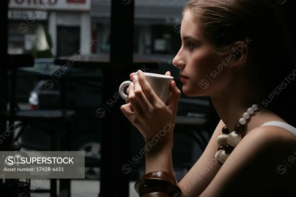 Young woman drinking coffee in cafe.