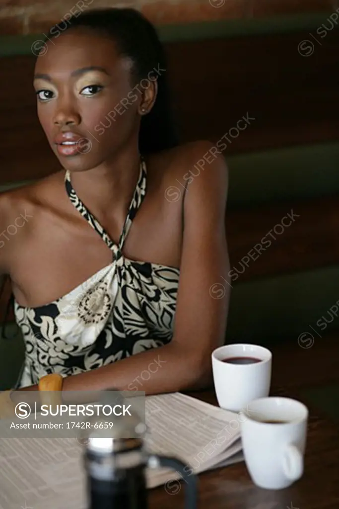 Young stylish African-American woman sitting in cafe.