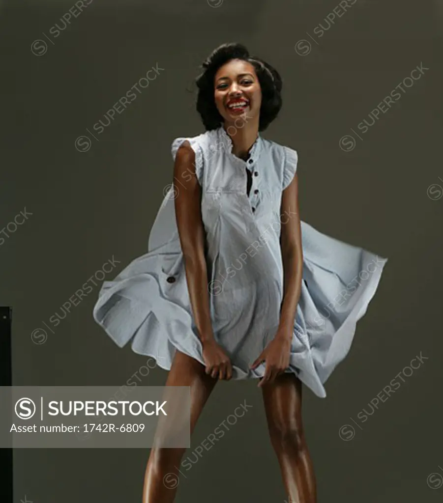 Young African American woman posing in dress, studio shot.