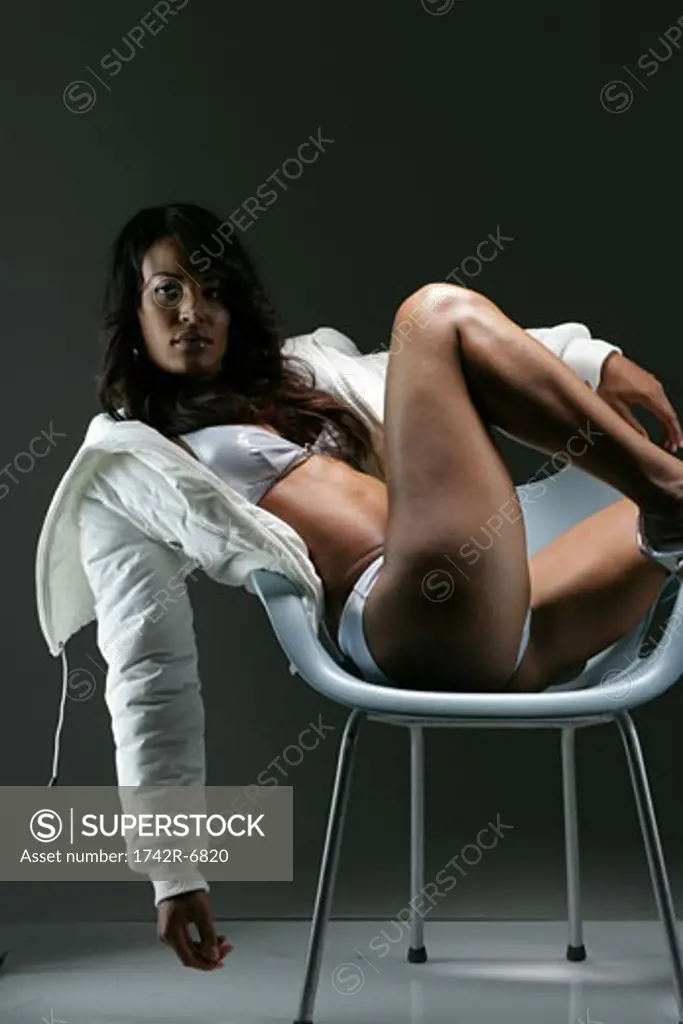 Young African American woman in bikini and jacket, studio shot.