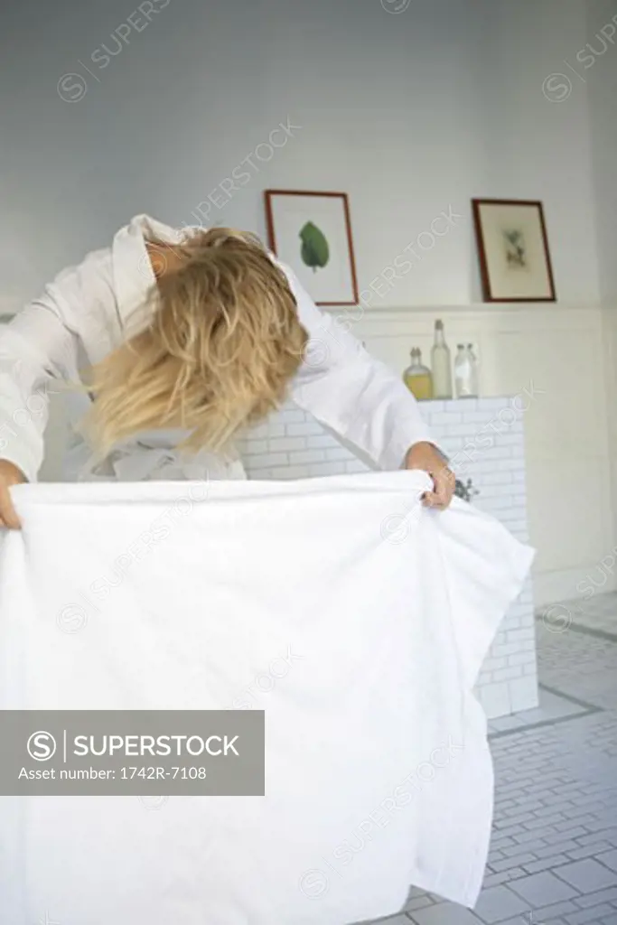 Woman drying hair with towel.