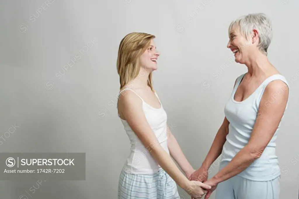 Mother and adult daughter holding hands.